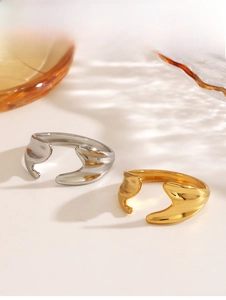 Detail showing irregular wavy liquid-style stainless steel open rings in gold and silver