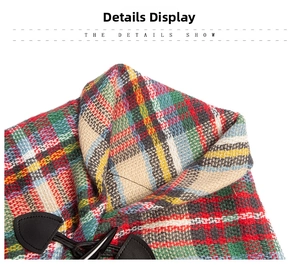 Detail of red and green plaid fabric featuring a black leather toggle button closure