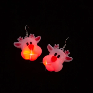 Close-up of glowing LED Christmas reindeer earrings with red light on black background
