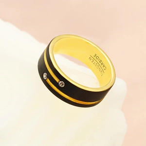 Macro view of matte black and gold tungsten carbide ring with inlaid cubic zirconia
