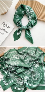 Close-up of green silk scarf featuring paisley patterns and white polka dots on fabric