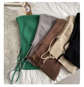 Flat lay of knit balaclava hoodies in green, gray, brown, beige, and black with drawstrings