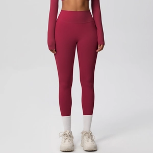 Front full view of dark red high-waisted seamless yoga leggings on model in studio
