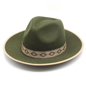 Detail of dark green wool felt jazz hat featuring geometric embroidery and contrast piping