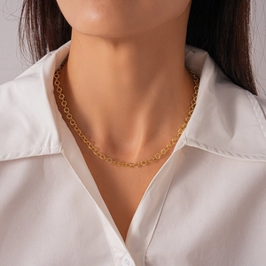 Close-up of a delicate golden geometric round link choker worn with a white shirt