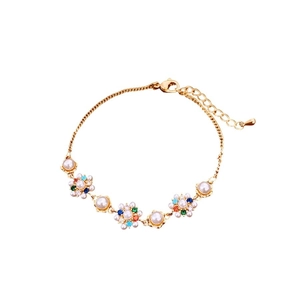Vintage style gold flower bracelet featuring white pearls and colorful rhinestones