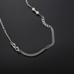 Macro shot of silver titanium steel chain necklace with integrated white pearls detail