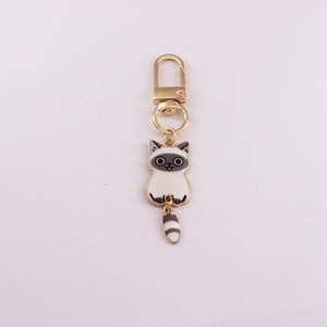 Close-up of a cartoon cat alloy keychain with golden lobster clasp on plain background