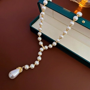 French vintage pearl necklace with diamond-set waterdrop pendant on green jewelry box