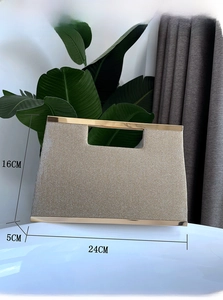Detailed view of champagne gold glitter clutch bag with metallic frame and top handle