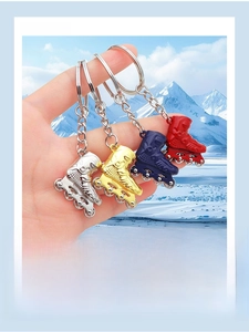 Detailed view of four colorful miniature skate shoe keychains held against a snowy background