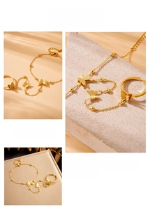 Detail of gold-plated butterfly ring-bracelet set with adjustable chain and matte texture
