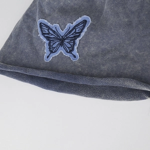 Washed blue denim slouchy beanie featuring a vintage butterfly embroidery detail