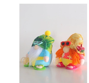 Macro shot of two summer beach gnomes wearing bikinis, sunglasses and hats