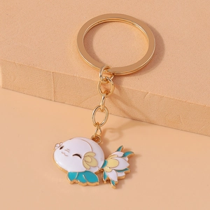 Close-up of golden koi fish keychain with white, yellow and cyan enamel details