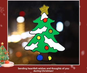 Macro view of a 3D layered Christmas tree window sticker with snow and colorful ornaments