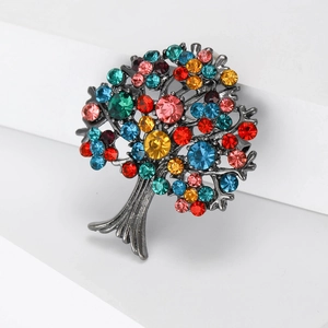 Detailed macro view of an intricate alloy tree of life brooch set with multi-colored crystals