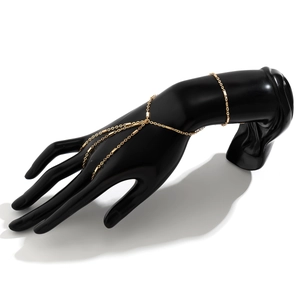 Detail of gold chain hand harness with metallic plates on a professional hand model
