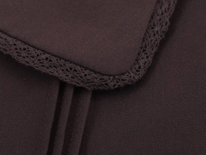 Detailed macro view of dark coffee fabric with delicate lace trim on the round collar