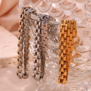 Detailed shot of 6mm steel watch-band choker necklaces in gold and silver on glass