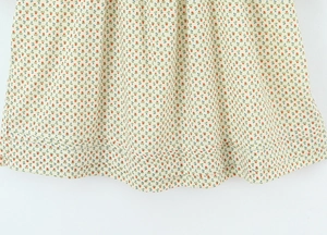 Close-up van rode bloemenprint op losse Franse midi-jurk met geplooide zoom en afwerking