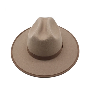 Detail of camel wool fedora hat featuring wide brim and decorative brown ribbon band