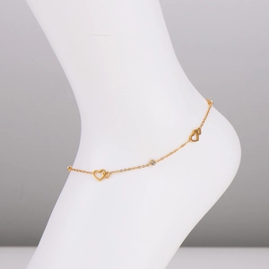 Minimalist gold hollow heart anklet with sparkling zircon on a white mannequin foot