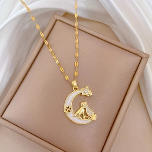 Golden moon cat necklace with zircon accents on a soft silk background setting