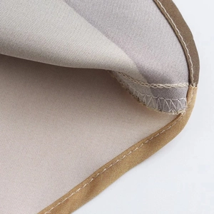 Macro detail of the reinforced double-stitched hem on the floral satin dress fabric