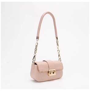 Detailed macro of pink crocodile pattern PU leather with golden metal clasp and chain