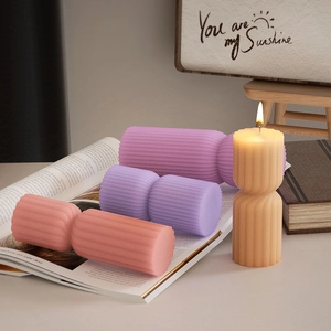 Close-up of ribbed pillar candles in pink, purple, and beige with vertical stripe textures