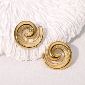 Minimalistische Vintage-Spiral-Ohrstecker in Gold mit Textur auf Korallenhintergrund