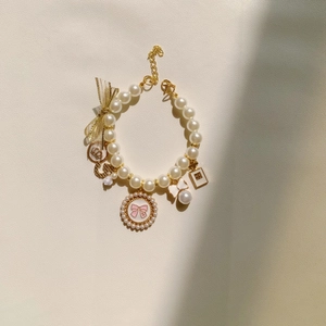 Elegant pearl pet collar necklace with gold charms like bow, crown and perfume bottle