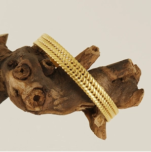 Detailed view of 18K gold plated stainless steel bracelet with wheat pattern texture