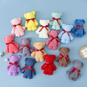 Colorful bear-shaped coral fleece towels with Just for you ribbons in a flat lay view