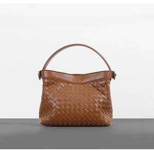 Detail shot of a dark brown woven leather handbag with classic intrecciato texture