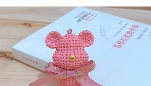 Detailed view of a pink resin bear keychain with a woven texture and LOVE ribbon