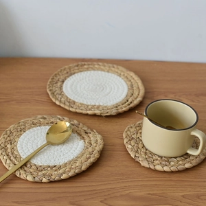 Close-up of woven cotton rope coasters in two-tone natural wood and white colors