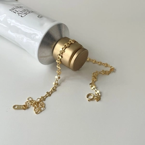 Macro shot of S925 sterling silver twisted chain bracelet in gold finish with logo tag