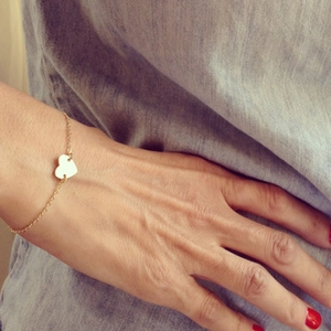 Bracelet cœur doré minimaliste au poignet avec une chaîne à maillons délicate
