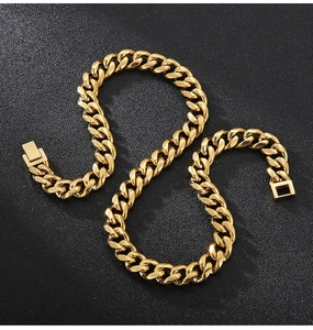Close-up of polished gold Cuban link chain with secure buckle on black matte surface