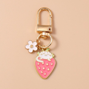 Cute pink strawberry keychain with white cat and flower charm in golden metal finish