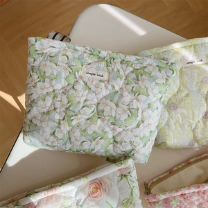 Close-up of quilted floral cotton makeup bags with zippers and soft padding texture