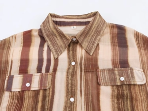 Dettaglio di camicia in chiffon a righe marroni con colletto, tasche e bottoni bianchi