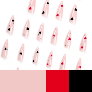 Pink stiletto press-on nails with red and black heart patterns and silver rhinestones
