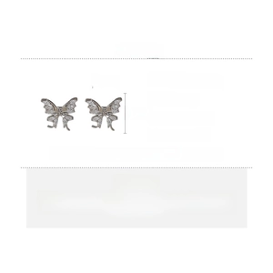 Detail view of butterfly ear cuffs made of copper and zircon with silver needle measurements