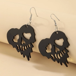 Macro detail of gothic black heart skull earrings with unique melting drop effect