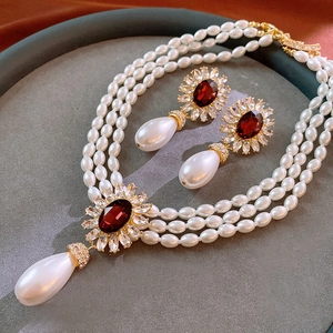 Détail du collier de perles à trois rangs avec pendentif rubis et boucles d'oreilles set
