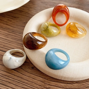 Gros plan de bagues colorées en résine marbrée au design ovale géométrique rétro