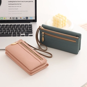 Detail of long leather wallets with leaf zipper pulls and lychee grain texture